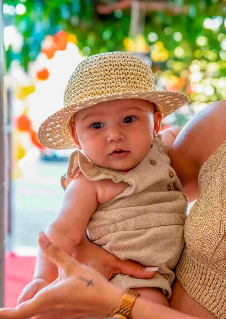 Bébé dans les bras de sa maman pendant un anniversaire familial