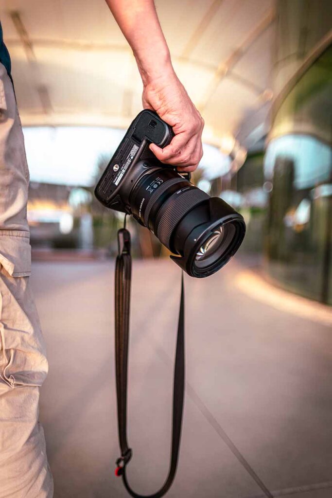 Photographe tenant un appareil photo professionnel prêt à capturer des moments précieux.