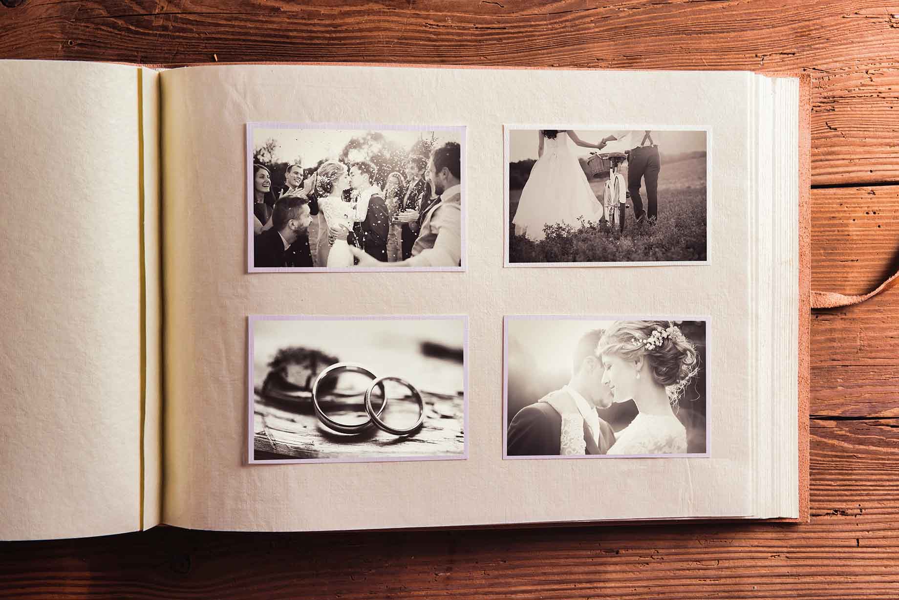 ouvenirs d'Amour : Album de Mariage Intemporel Album photo ouvert montrant une sélection de photographies de mariage en sépia, incluant le couple marié et les alliances.