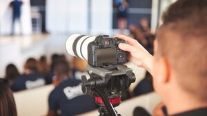 Photographe en action avec un appareil professionnel lors d'un séminaire d'entreprise.