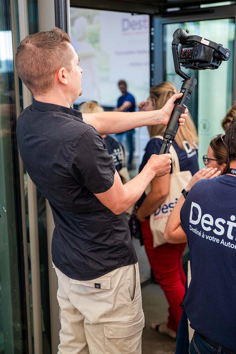 Vidéaste en tournage d'un film institutionnel lors d'un événement professionnel.