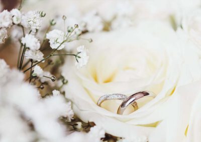 Photo, vidéo et duo photo + vidéo pour votre mariage à Aix-en-Provence 15 Deux alliances posées sur une rose blanche au milieu de petites fleurs blanches