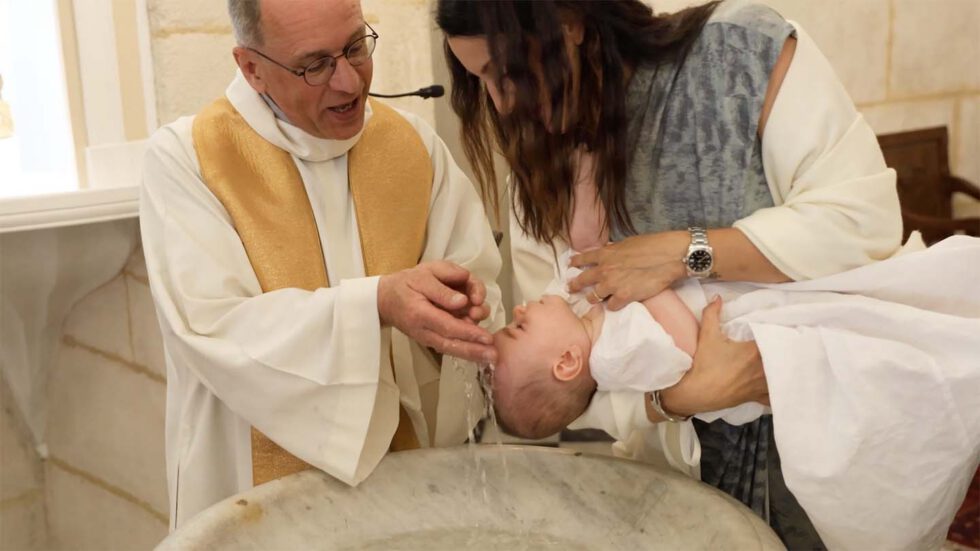 Cérémonie familiale à l’église avec l’enfant dans les bras de sa maman