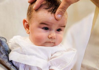 Le prêtre fait le signe de croix sur le front de Léanza pendant son baptême à Ensuès-la-Redonne