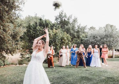 Maëlenn lance son bouquet derrière elle pendant le lancer du bouquet en extérieur