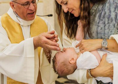 Le prêtre baptise Léanza pendant la cérémonie à l’église d’Ensuès-la-Redonne pendant que sa mère la porte
