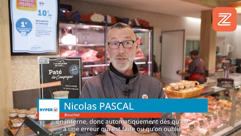 Plan mi-buste en magasin (rayon en arrière-plan), micro-cravate discret, lumière douce Interview témoignage client en magasin pour Zest HACCP (Phytocontrol), format sous-titré.