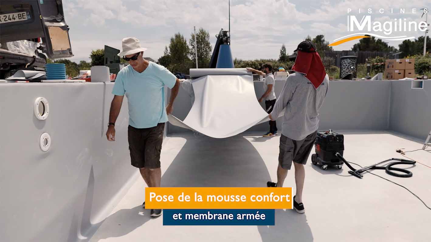 Pose de la membrane armée et mousse Ouvriers qui tirent la membrane de la piscine