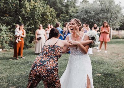 Photo, vidéo et duo photo + vidéo pour votre mariage à Aix-en-Provence 13 Une invitée attrape Maëlenn avec enthousiasme après le lancer du bouquet en extérieur