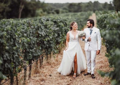 Maëlenn et Joffrey marchent dans les vignes en se regardant pendant leur séance couple