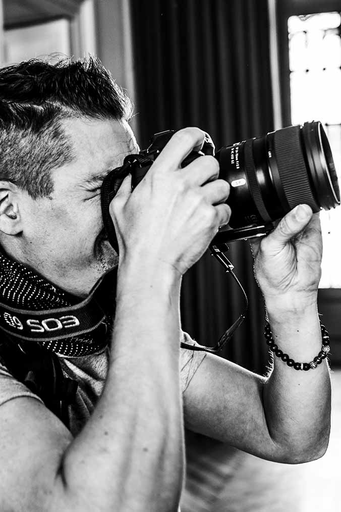 Photographe en noir et blanc en train de prendre des photos pendant un mariage