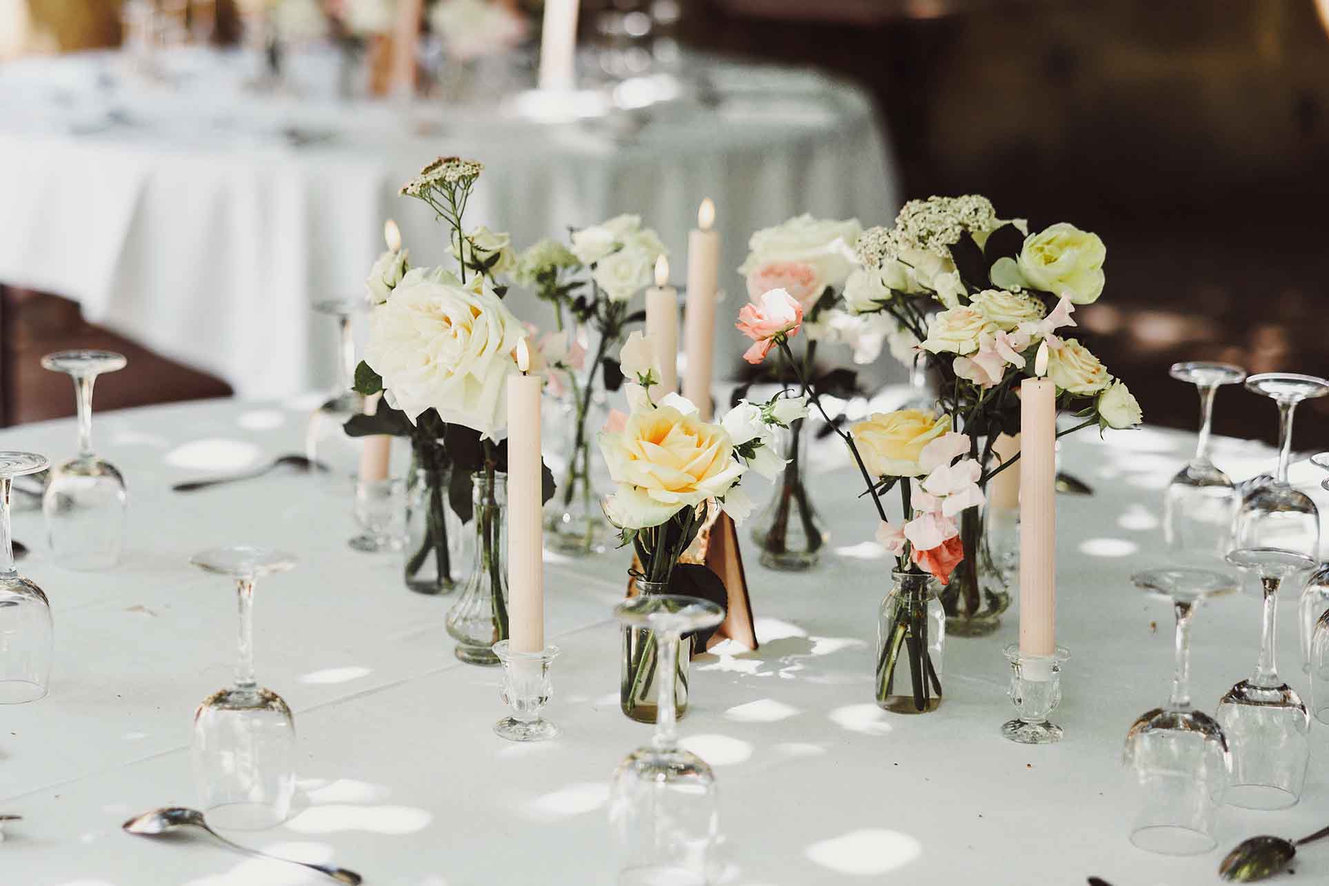 Décoration florale de table au mariage Table de réception décorée avec fleurs, bougies et verres pour le mariage