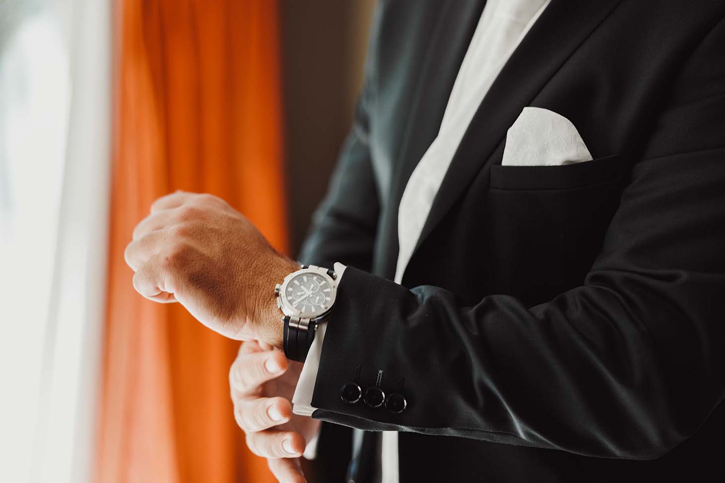 Détail de la montre du marié Le marié ajuste sa montre pendant les préparatifs