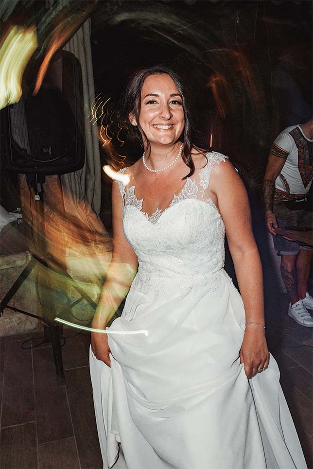 Portrait de la mariée sur la piste de danse La mariée sourit pendant la soirée avec des traces lumineuses autour d’elle