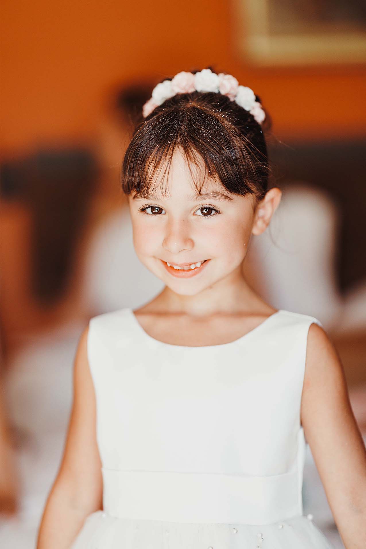 Portrait d’une enfant d’honneur Portrait d’une enfant d’honneur en robe blanche souriant face à l’objectif