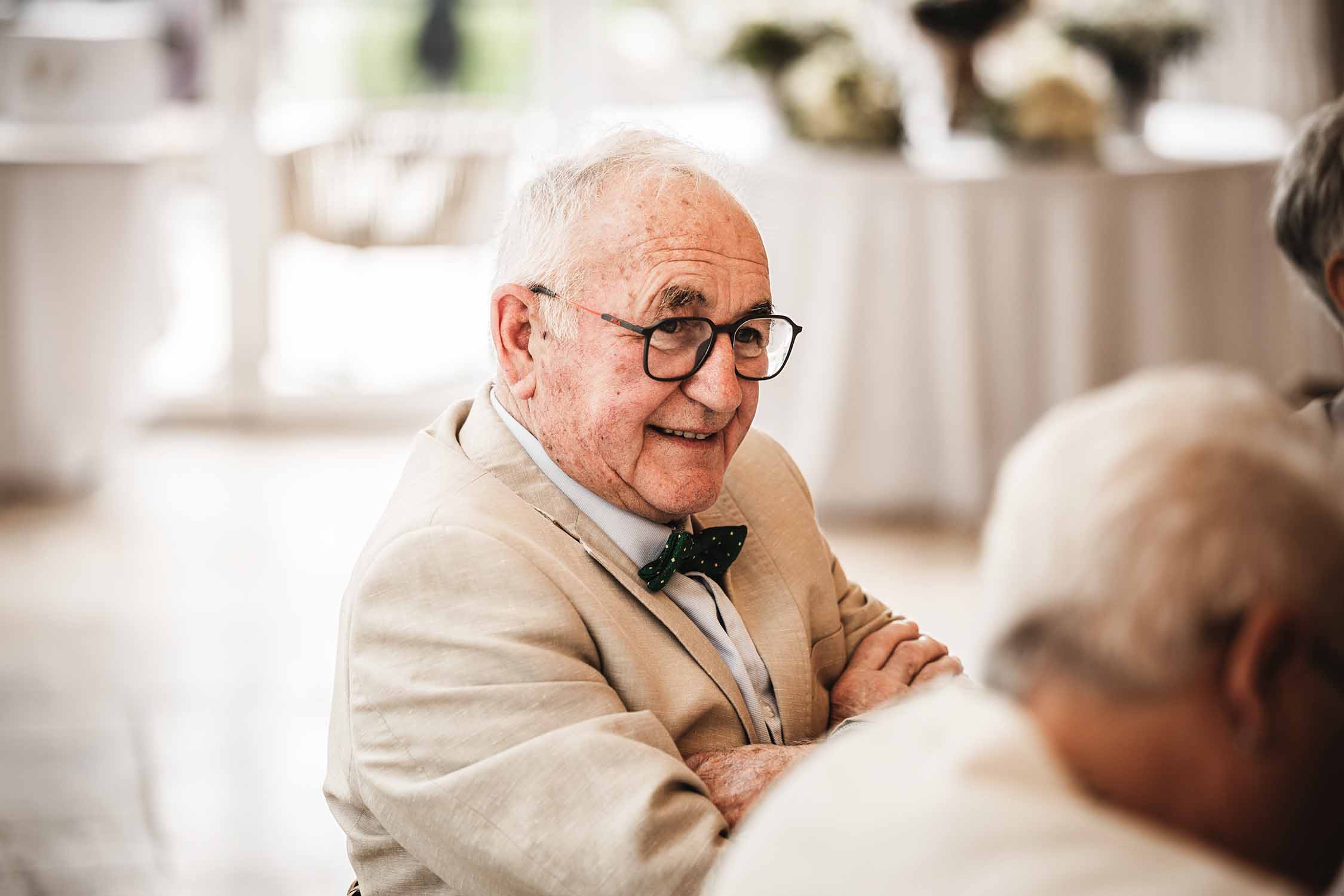 Invité souriant pendant le repas de mariage Invité souriant assis à table pendant le repas d’un mariage à la Bastide de Venelles