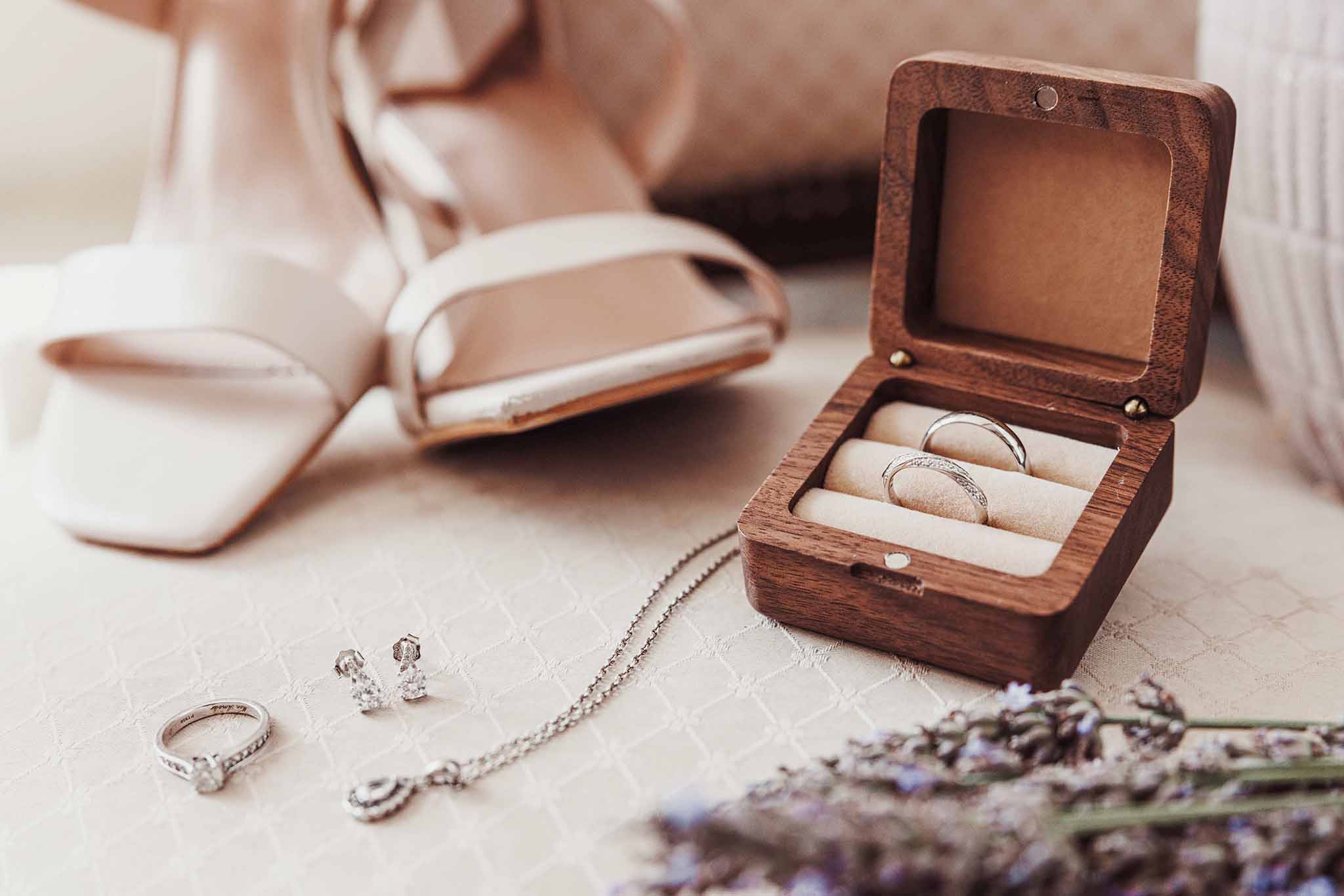 Alliances et détails de mariage Alliances dans un écrin en bois avec chaussures et bijoux de mariée