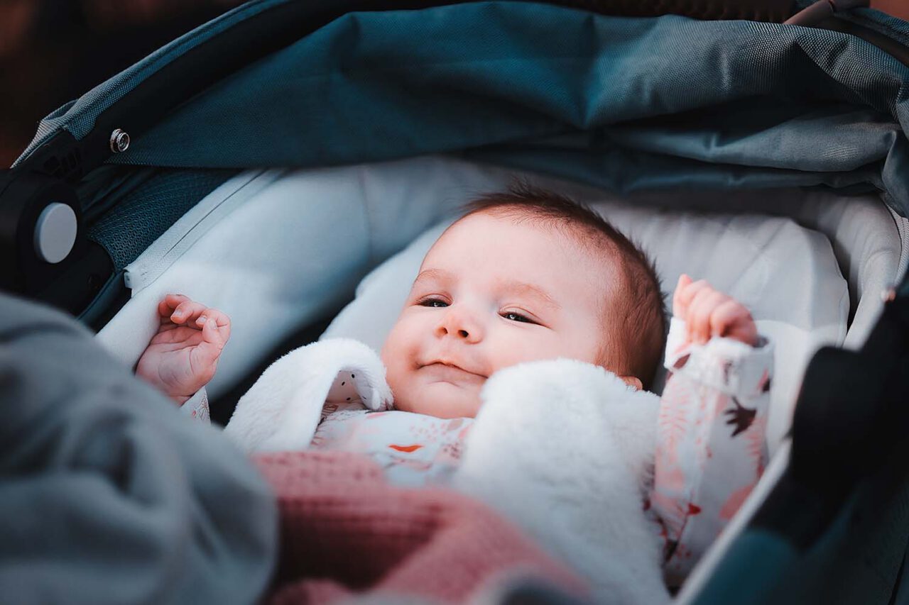 Photographe famille Miramas : bébé souriant dans sa poussette pendant la séance