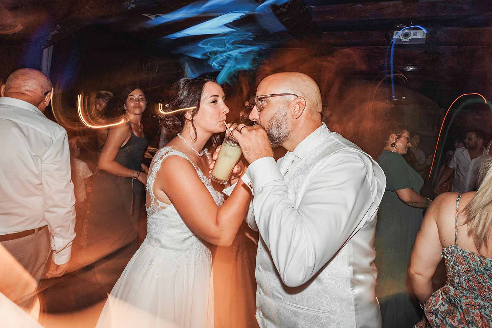 Mariés partageant un verre sur la piste de danse pendant la soirée de mariage