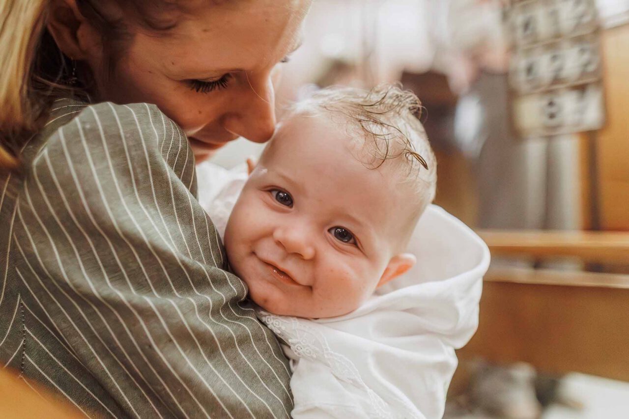 Photographe baptême Le Tholonet pour un portrait naturel d’Arthur dans les bras de sa maman