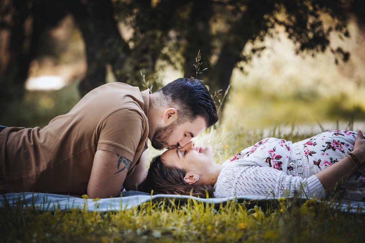 Photographe grossesse Martigues : couple allongé dans l’herbe pendant la séance