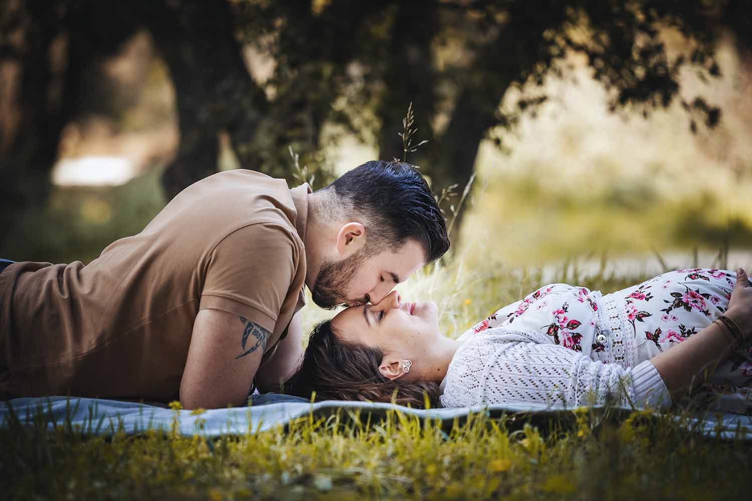 Baiser de Christophe et Laura pendant une séance photo grossesse en extérieur
