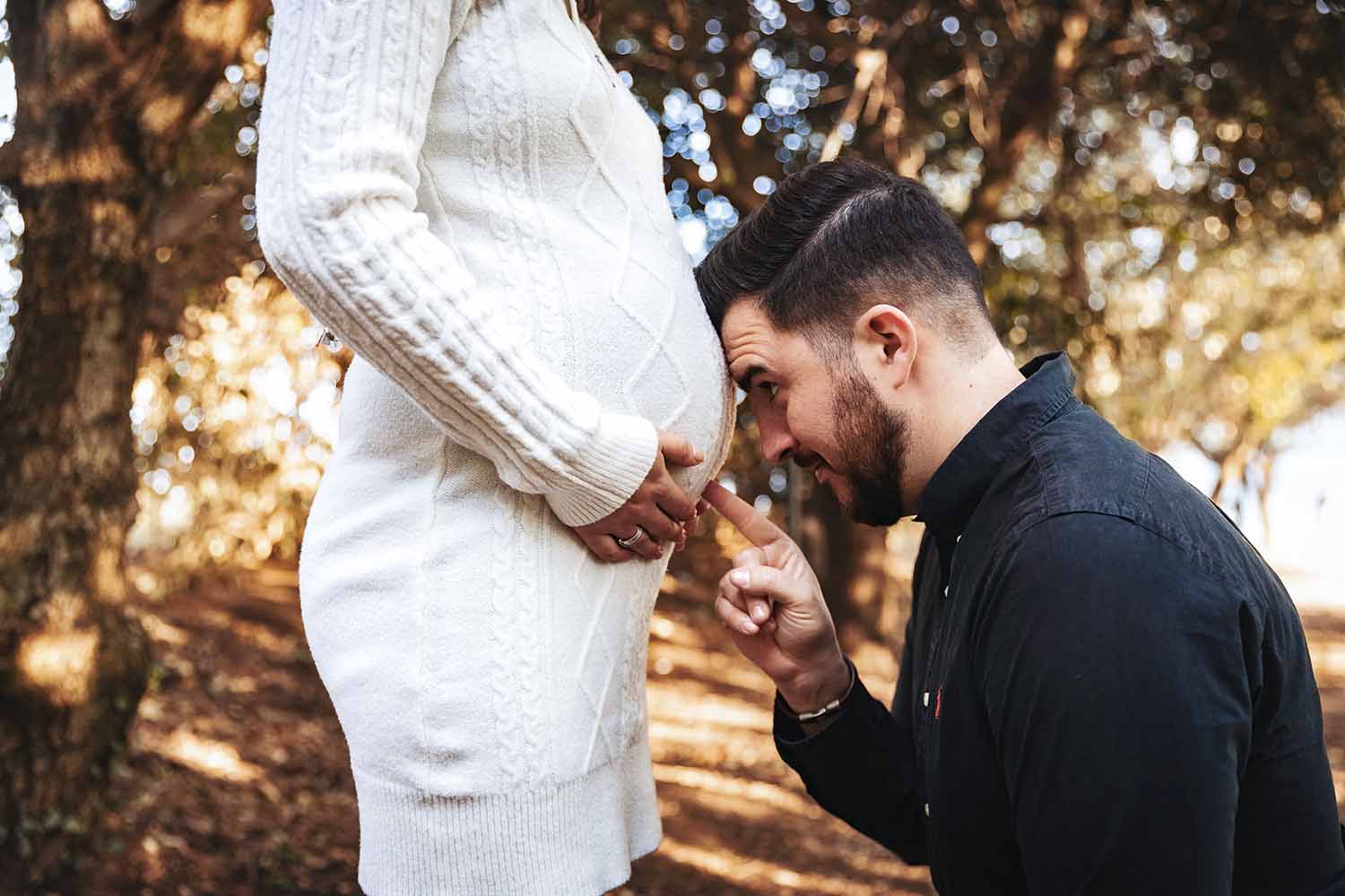Geste tendre autour du ventre pendant une séance photo grossesse