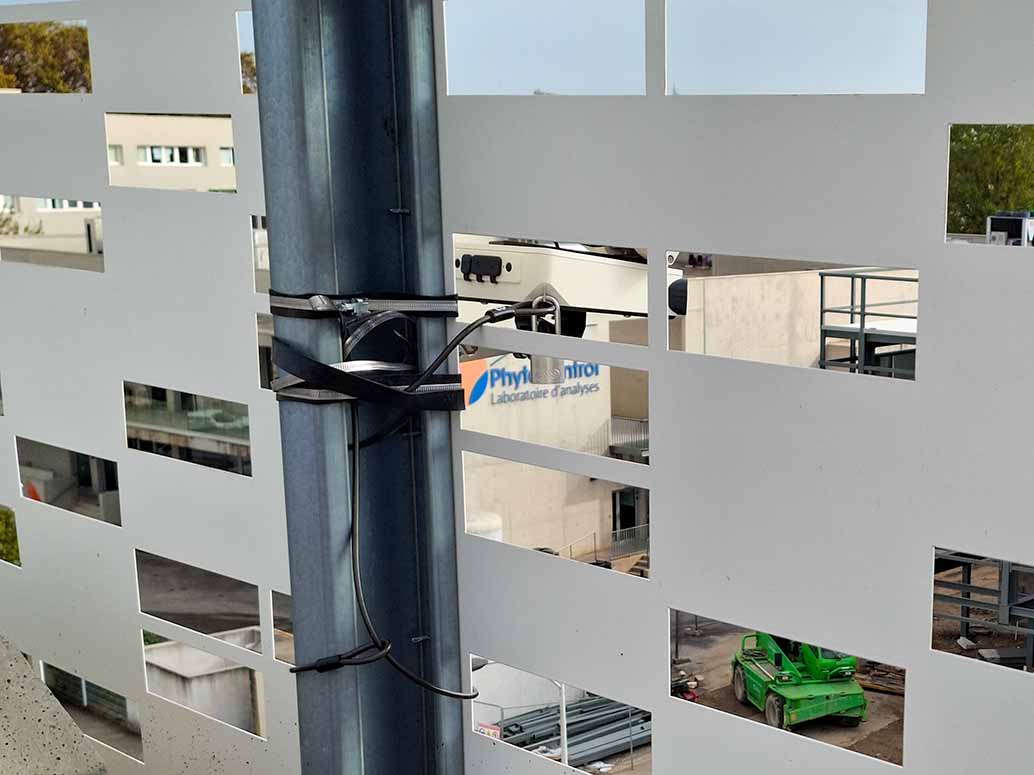 Caméra timelapse fixée sans perçage par serre-joint sur une structure métallique